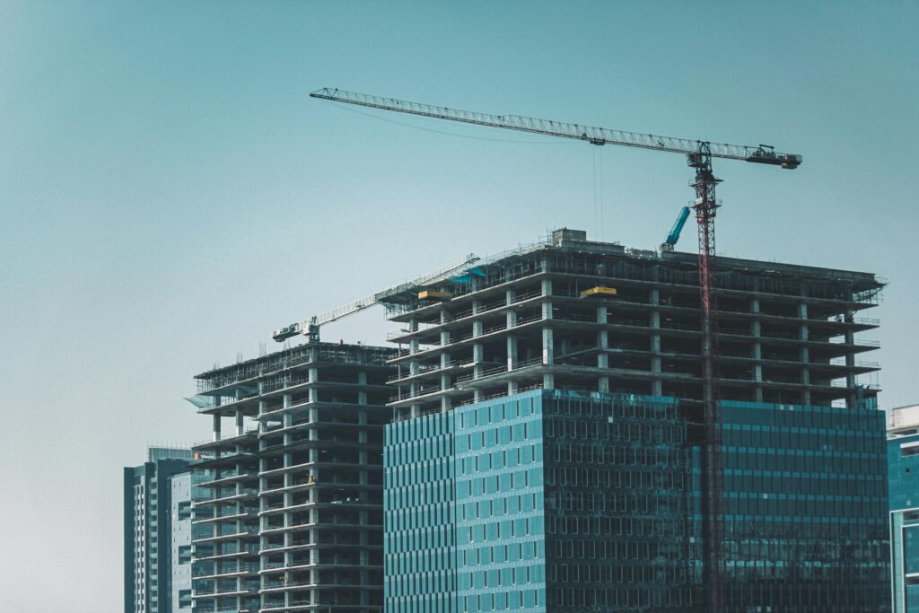 pexels photo 16331733 16331733 Skyline view of modern skyscrapers under construction with cranes against a clear sky.