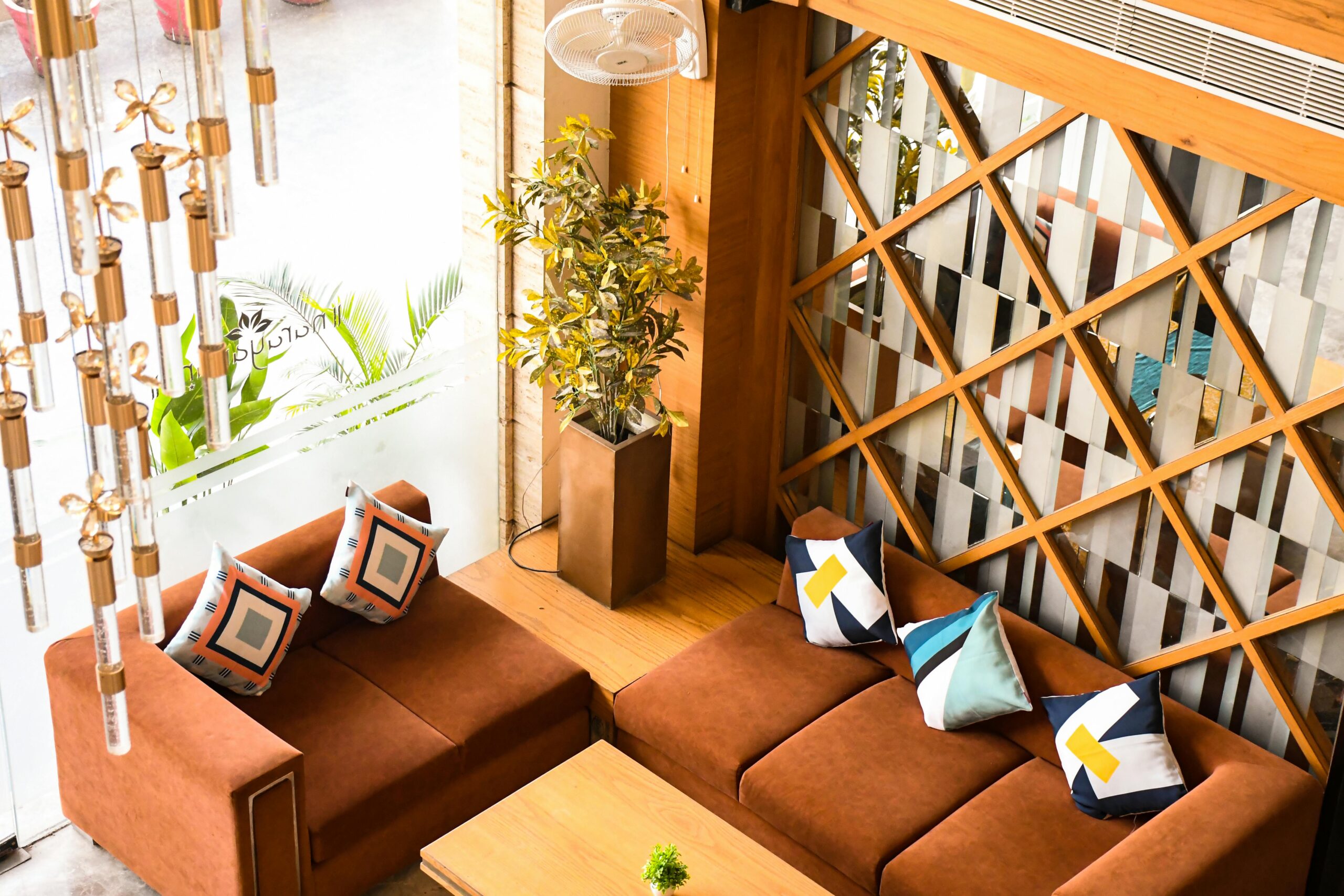 Stylish living room with brown sofas, decorative pillows, and modern decor in a cozy setting.