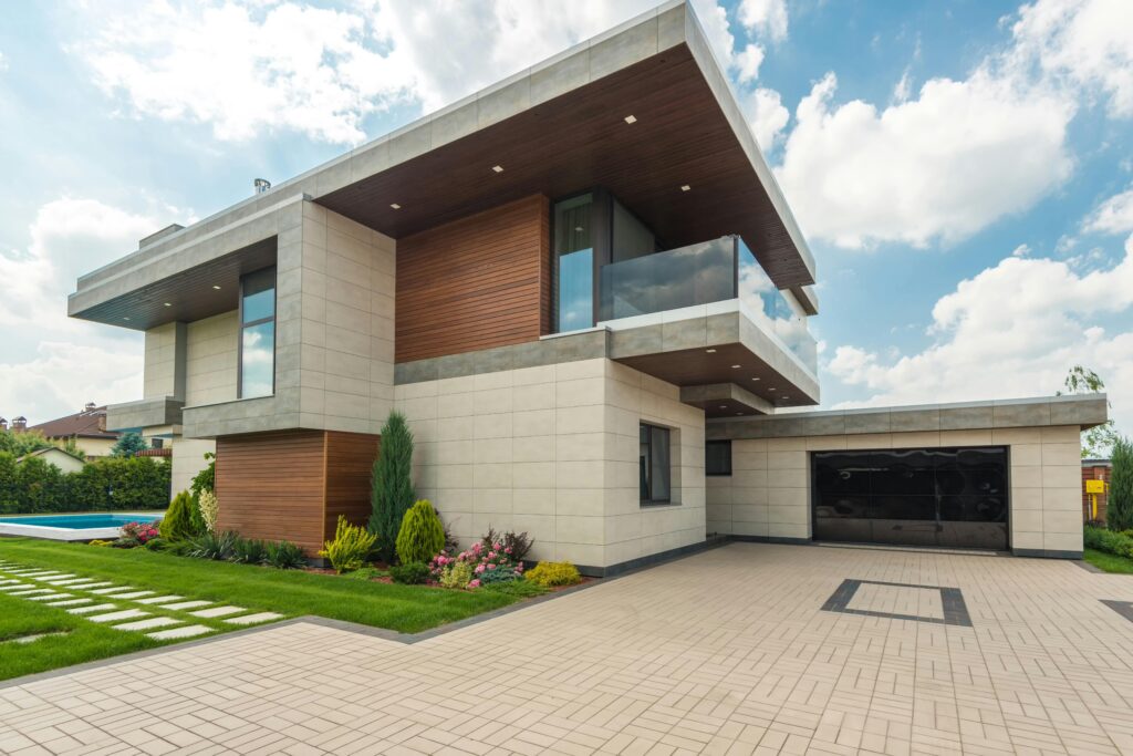 pexels photo 8134847 8134847 Contemporary luxury house with a sleek design, lush garden, and blue sky.